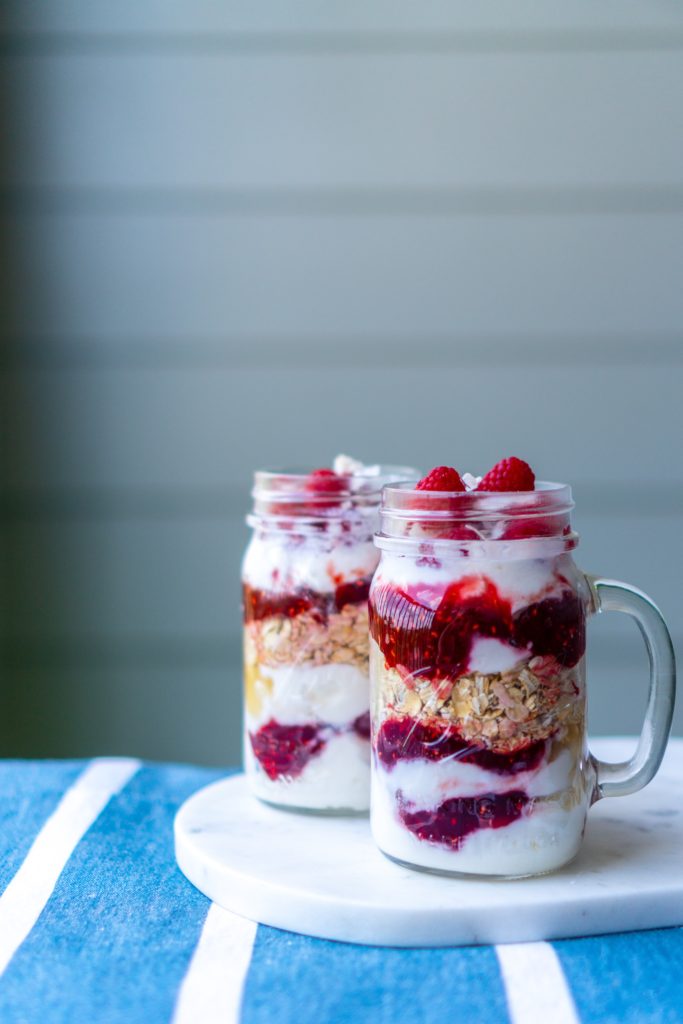 jars of overnight oats with yogurt and berry jam