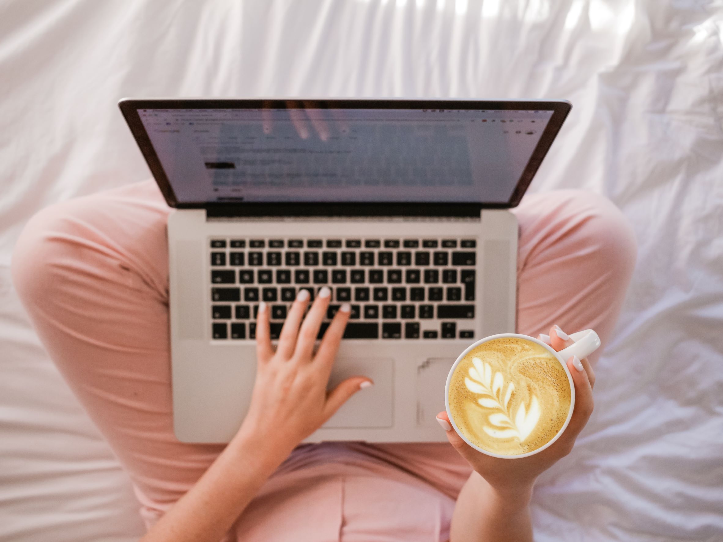Blogger with laptop holding cup of coffee