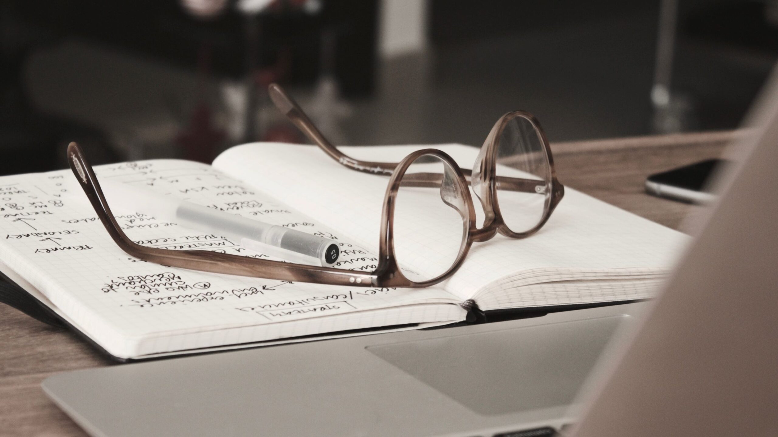 glasses set on notebook during blogging research